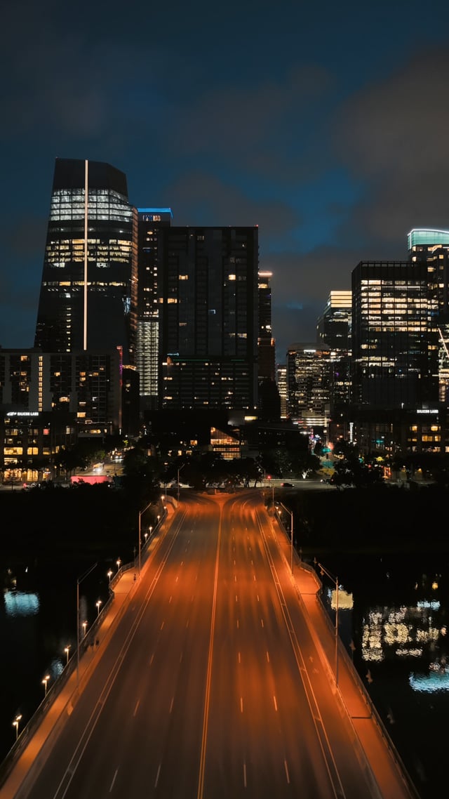 Downtown Austin skyline and a lit roadway before sunrise