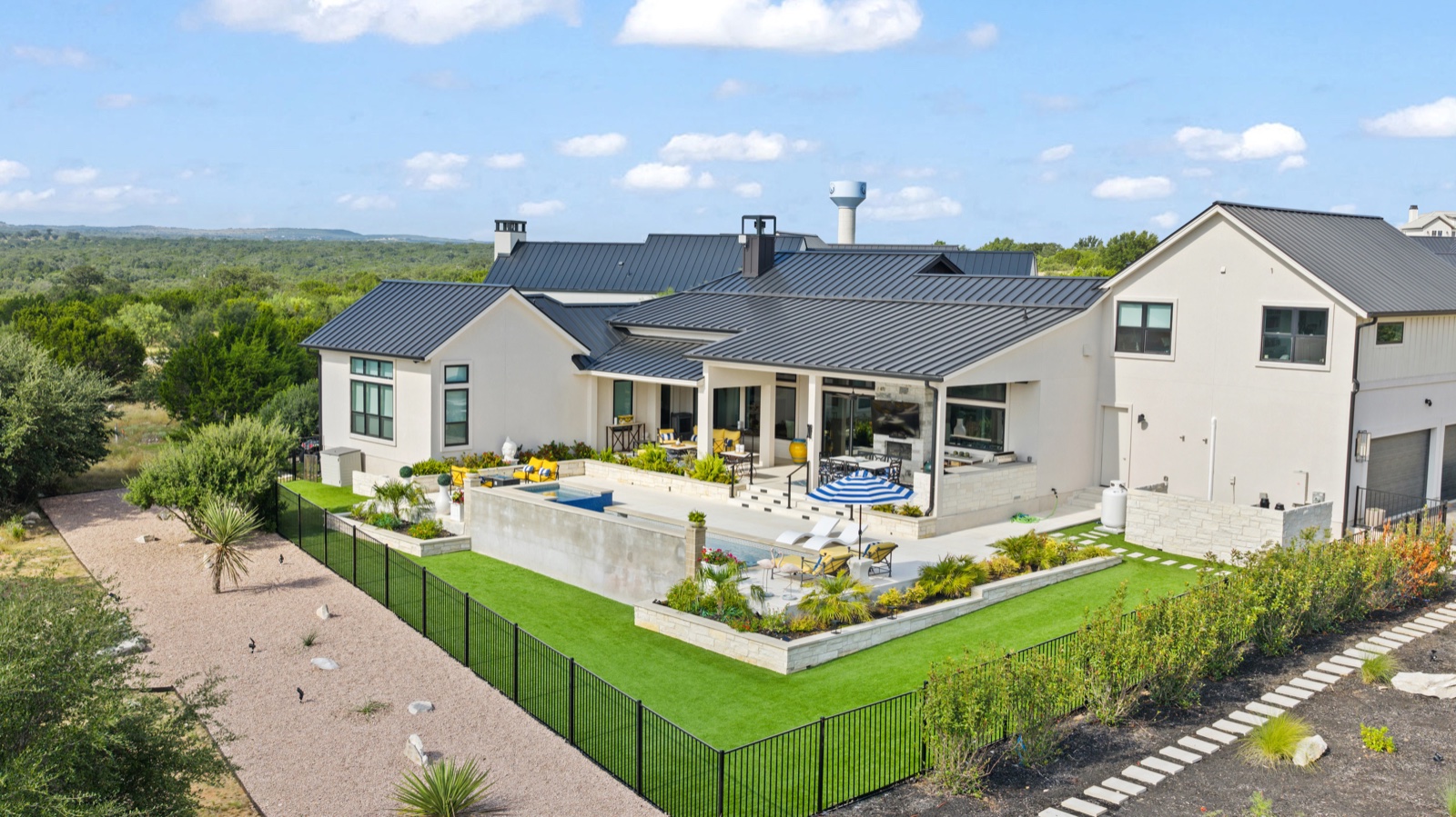 Aerial view of a home, pool, and outdoor grounds.