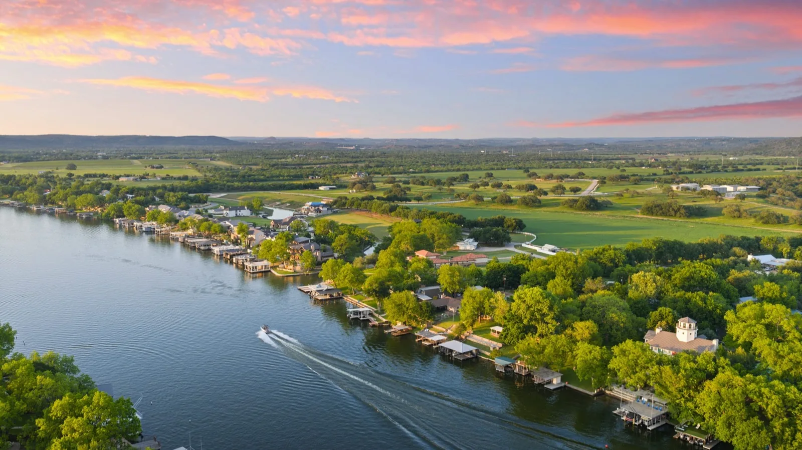 Waterfront community, docks, and open countryside at sunset