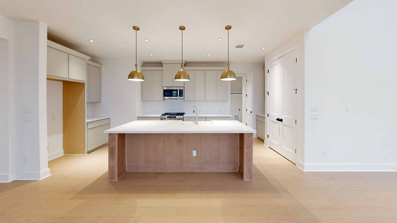 Kitchen in the 1840 Monopoly Path Matterport tour with an oak island and pendant lights
