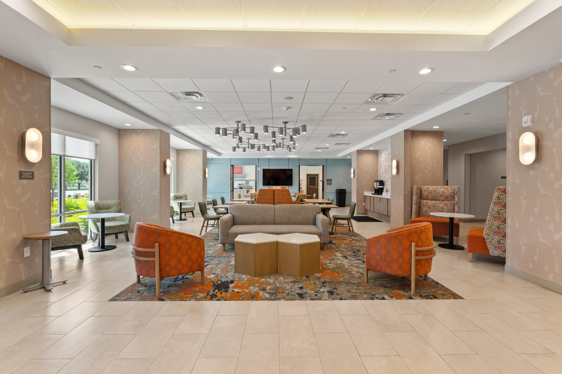 Welcoming hotel lounge with seating, warm accents, and natural light.