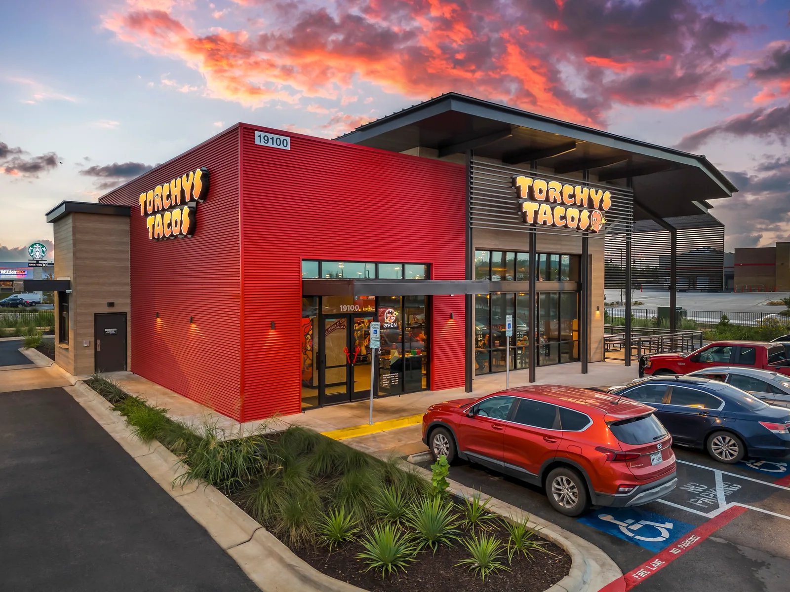 Torchy's Tacos storefront illuminated at dusk