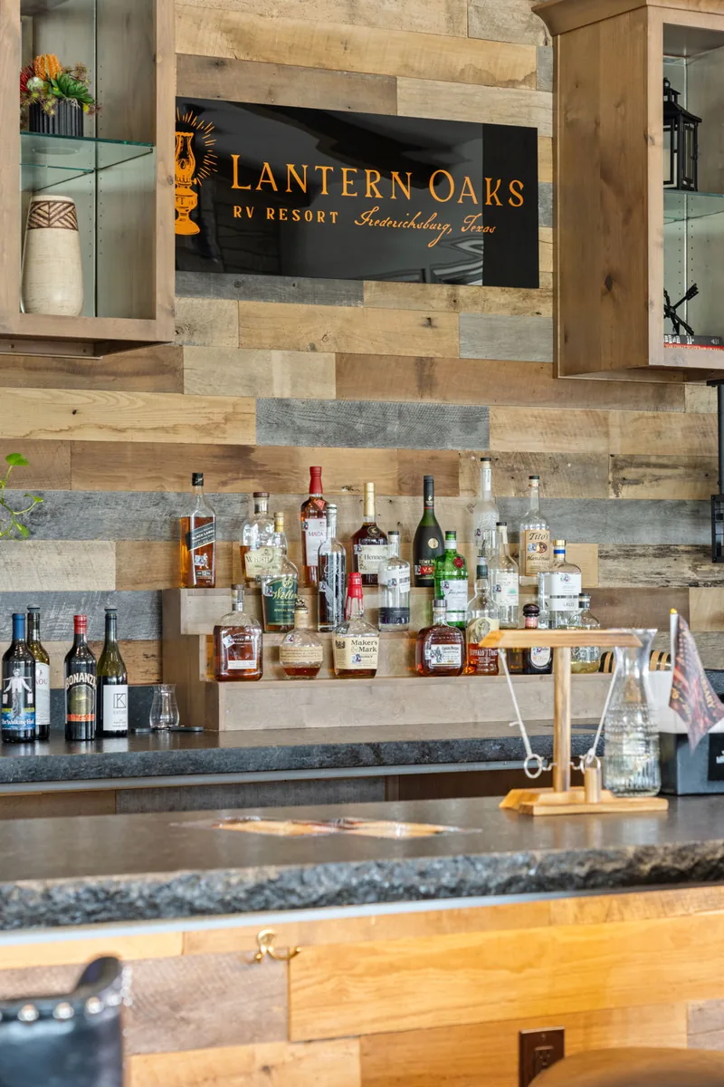Resort bar with a stone wall, wood counter and illuminated bottles