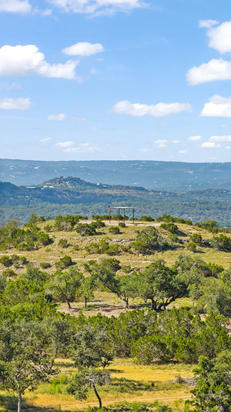 Rocky Hill Country terrain with green vegetation and distant hills