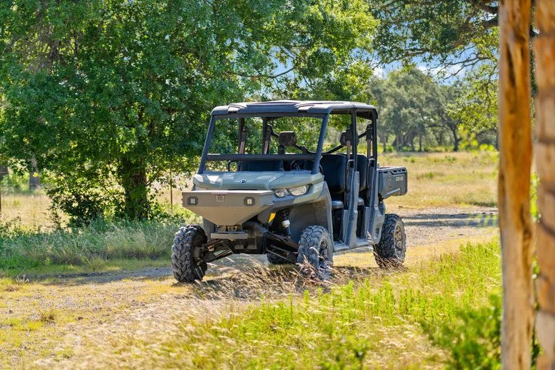 Ranch utility vehicle beside trees and a rough track