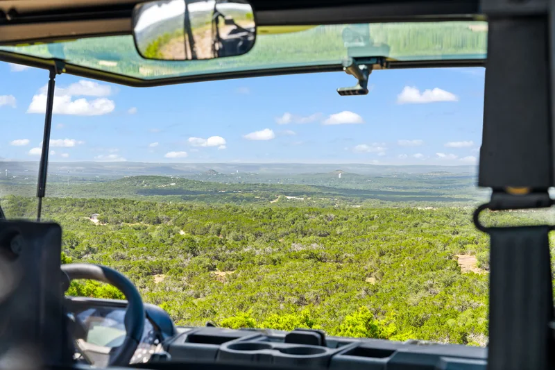 View of open ranch country from inside a utility vehicle