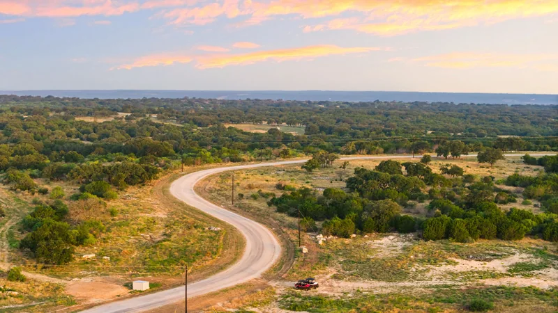 Aerial view of a road winding through a large tract of Hill Country land