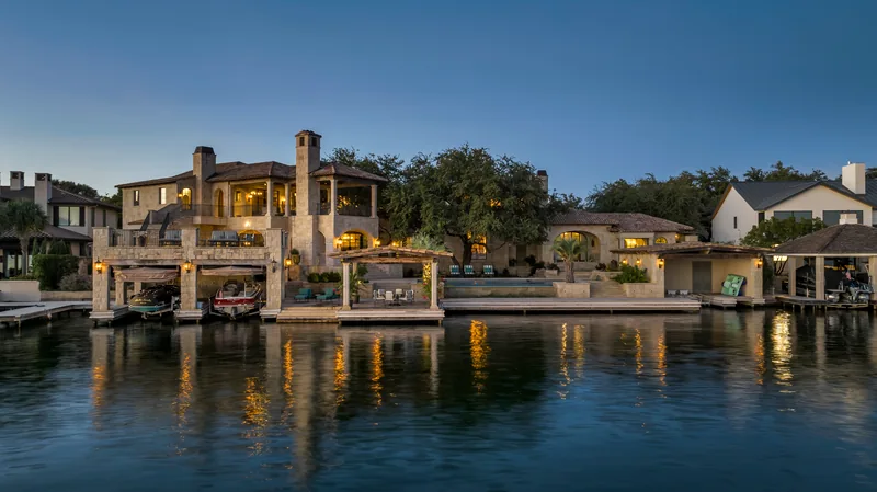 Waterfront home illuminated at blue hour with reflections on the lake