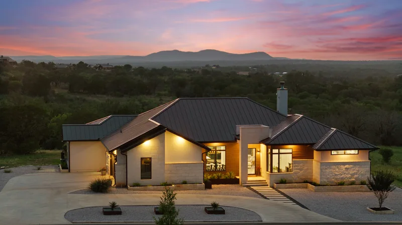 Single-story home beneath a pink Hill Country sky