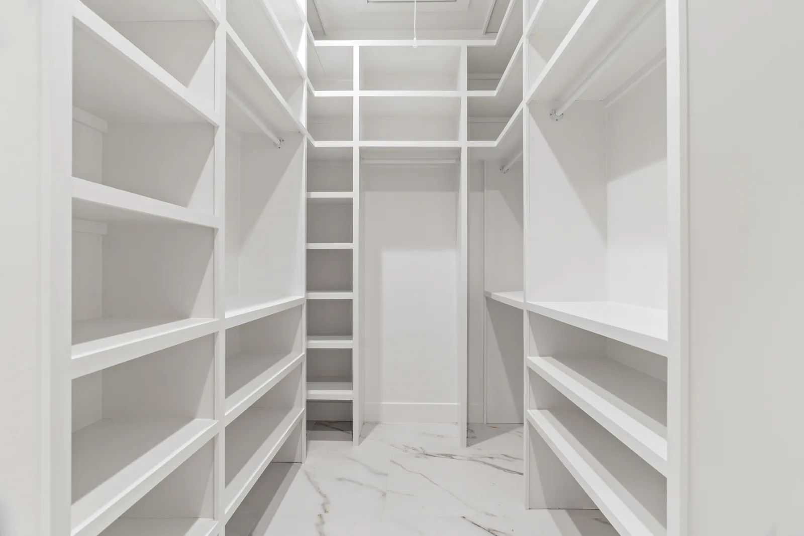 Walk-in closet with fitted white shelving