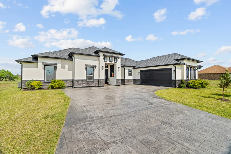 Contemporary home with landscaped lawn and a wide paved approach