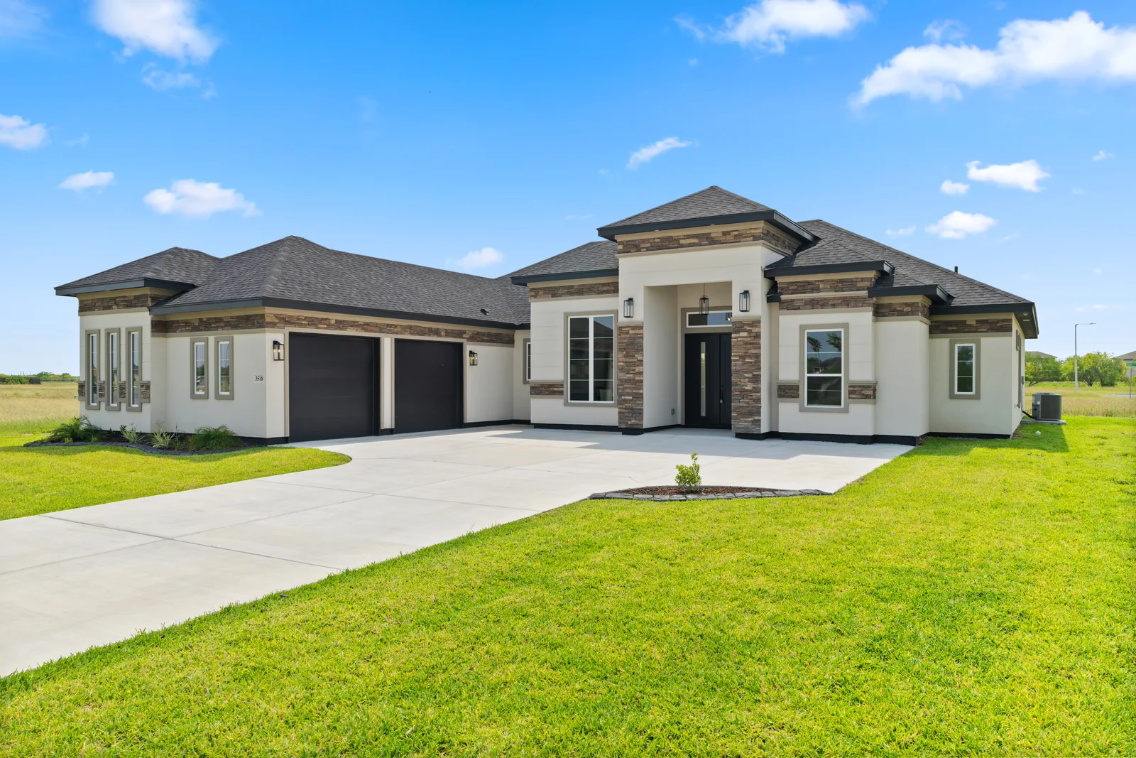 Light-colored single-story home with a covered entrance and green lawn