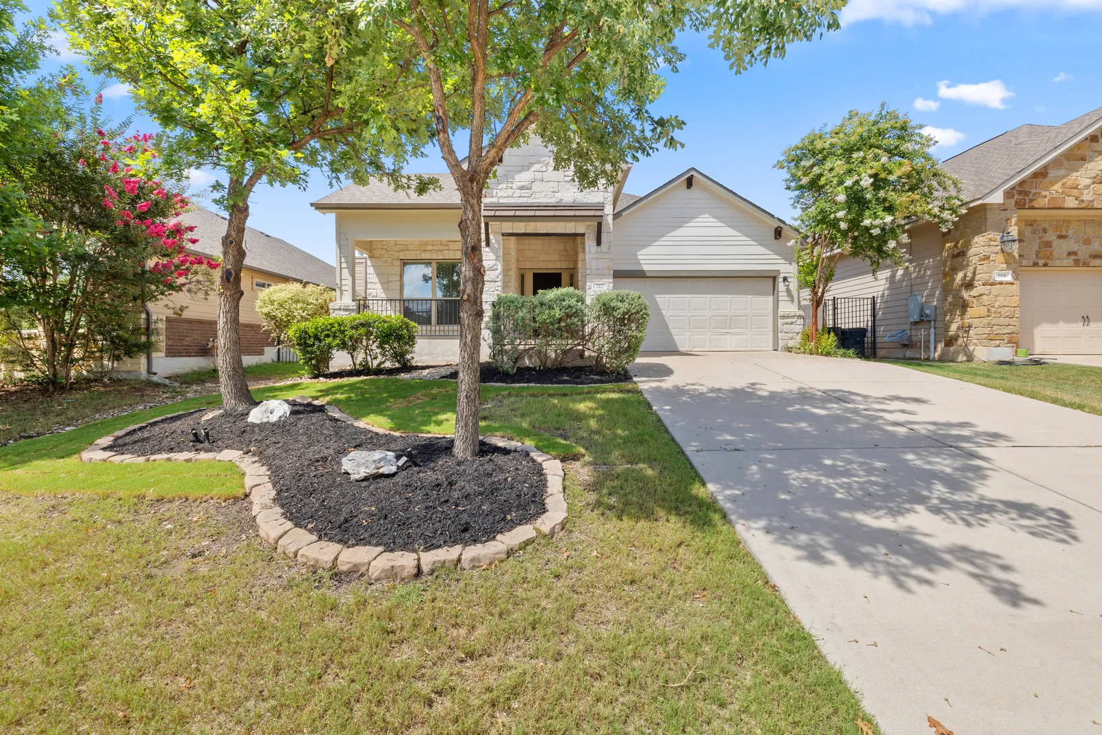 Residential exterior with a shaded front lawn