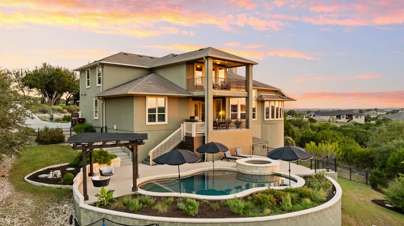 Large home and swimming pool under a vivid evening sky