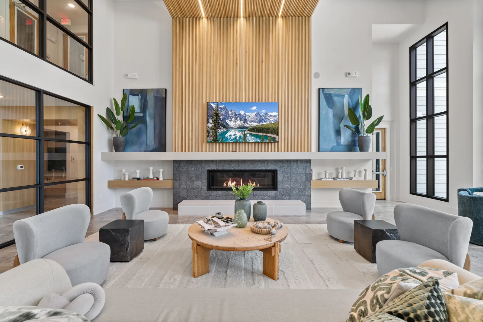 Apartment community lounge with a fireplace, slatted wood wall and comfortable seating
