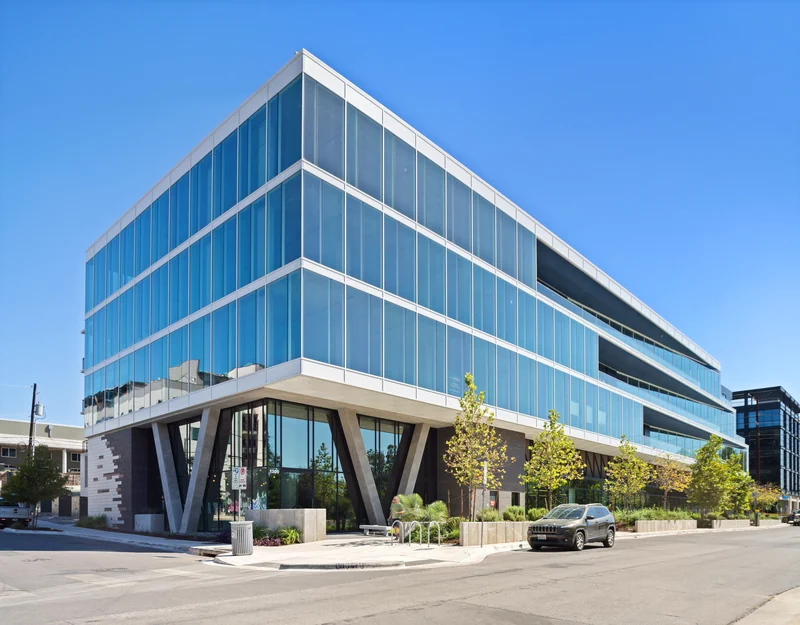 Glass-fronted office building at a landscaped street corner