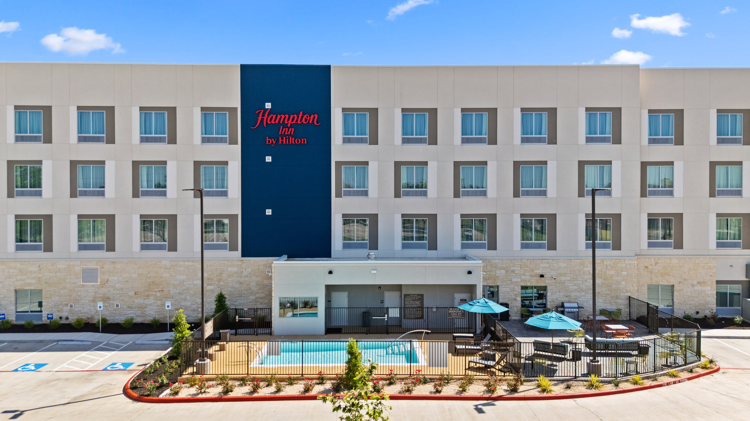Hampton Inn hotel, pool and outdoor terrace beneath a clear blue sky