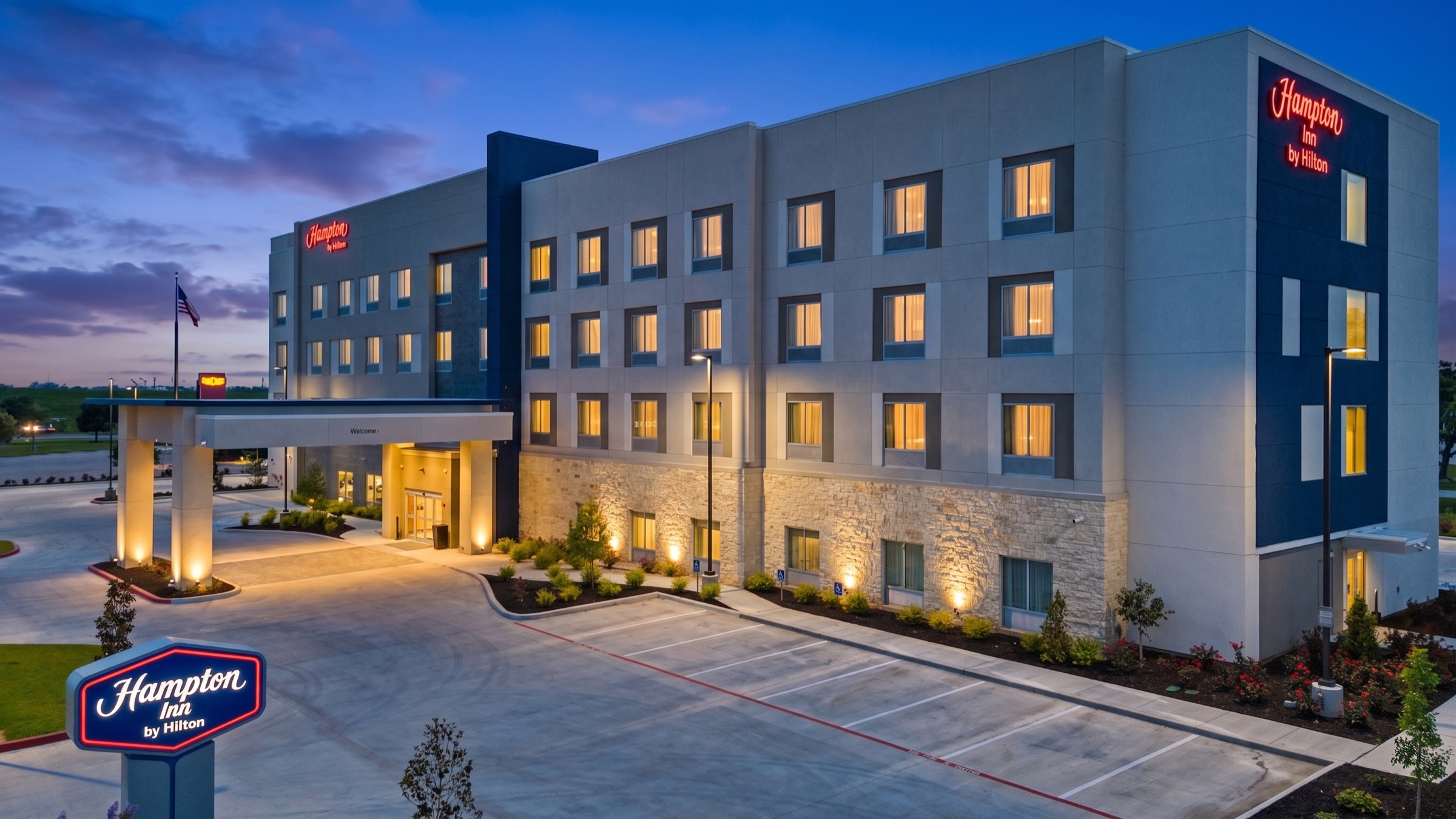 Hampton Inn hotel exterior illuminated at twilight