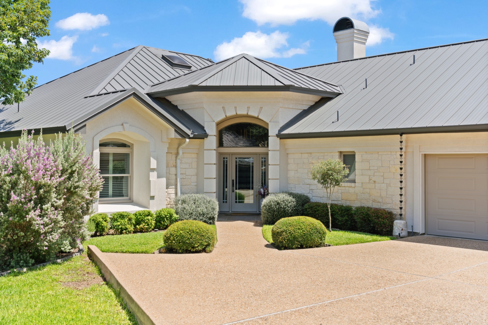 Stone residence with a landscaped front approach