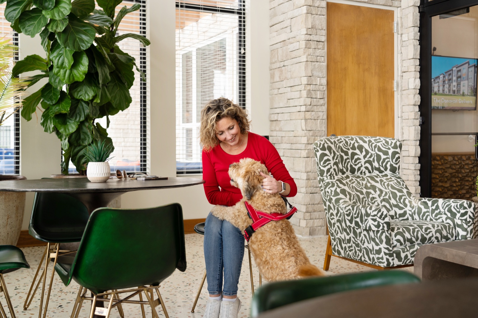 Resident spending time with her dog in a furnished apartment community lounge