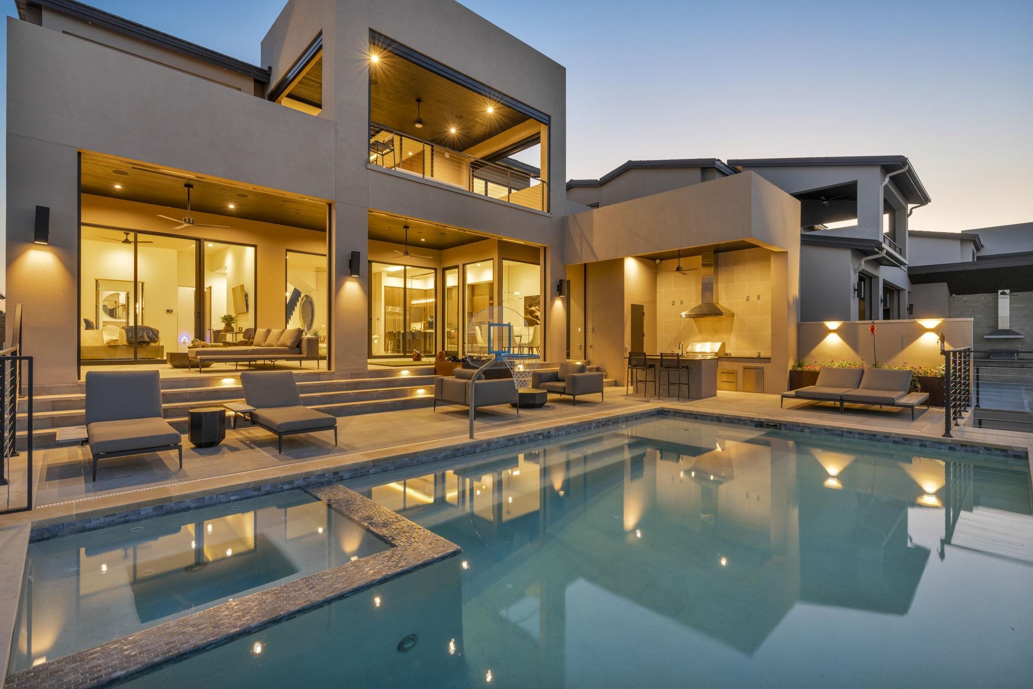 Illuminated Hill Country home and swimming pool at twilight