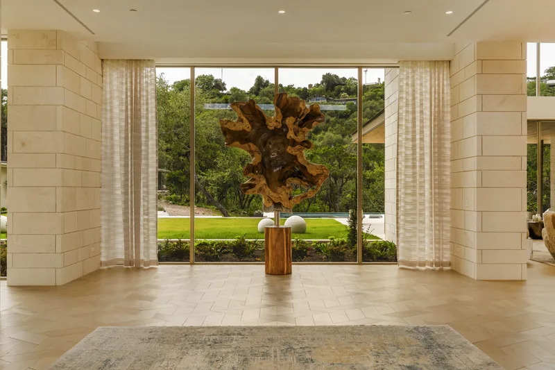 A symmetrical stone interior framing sculpture and the garden beyond