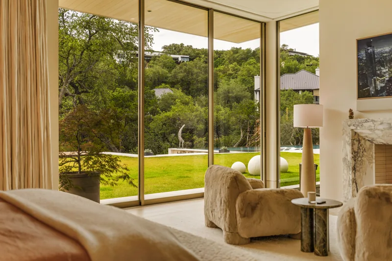 Glazed lounge with warm timber soffit and a view into the trees