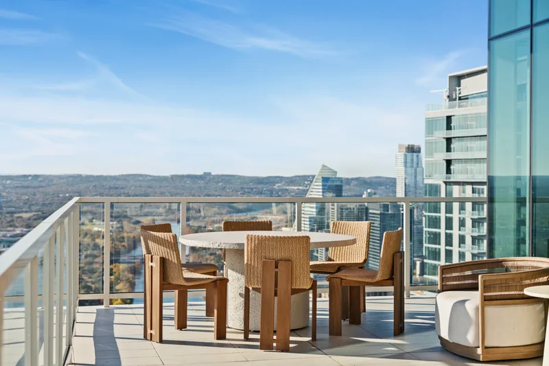 Timber dining furniture on a high-rise terrace overlooking Austin