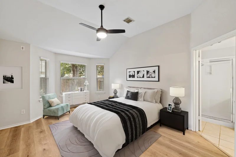 The same bedroom with a bed, bedside tables, chair and decor added digitally