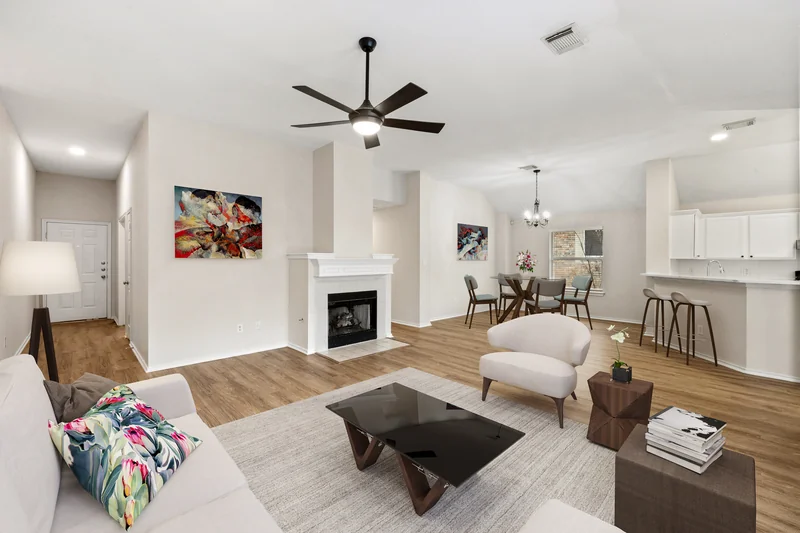 Open living and dining area with seating, dining furniture and art added digitally