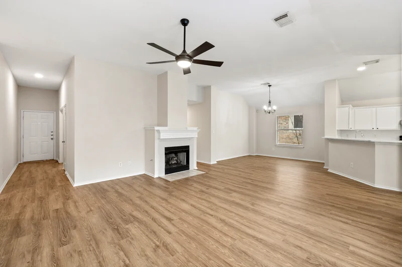 Unfurnished open living and dining area with a fireplace and kitchen counter