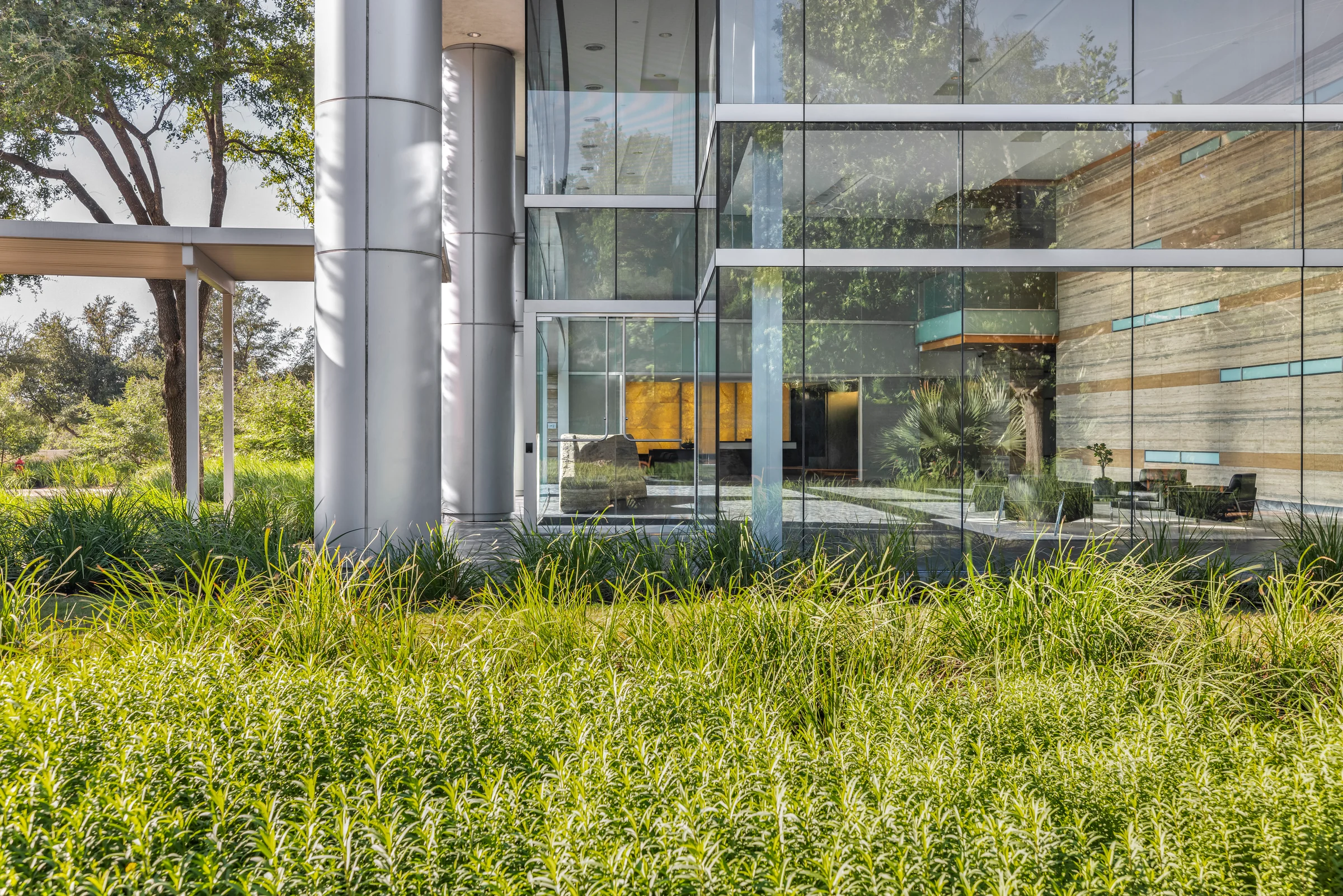 Glass-fronted commercial building surrounded by landscaping