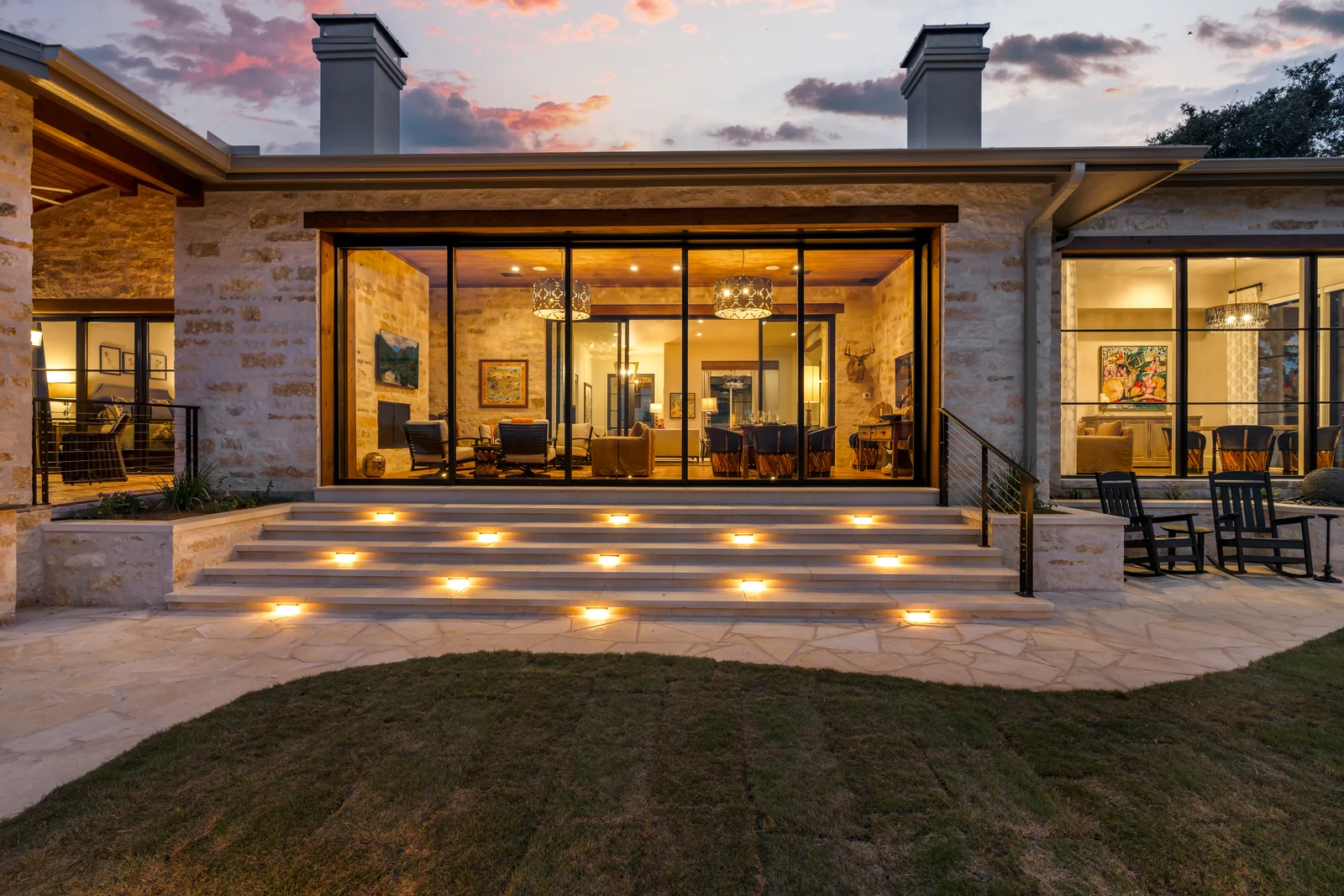Blazing Star home with warm interior light and illuminated stone steps at twilight