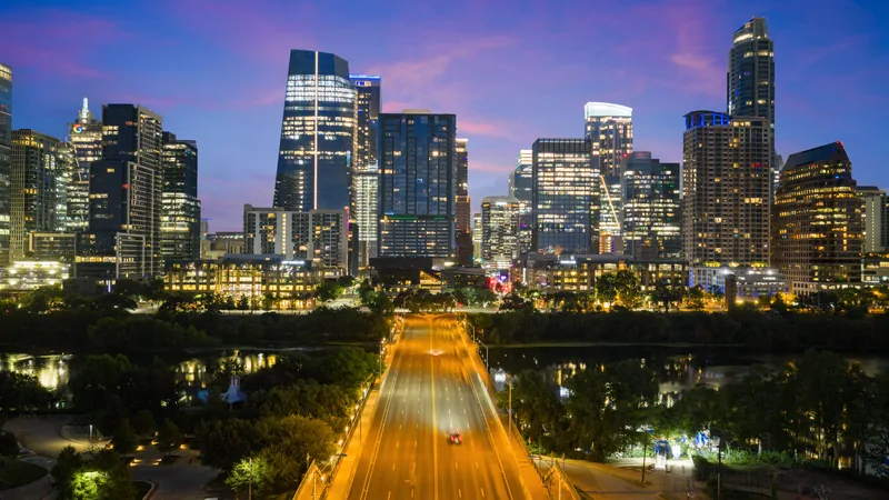 Downtown Austin skyline and illuminated bridge at blue hour