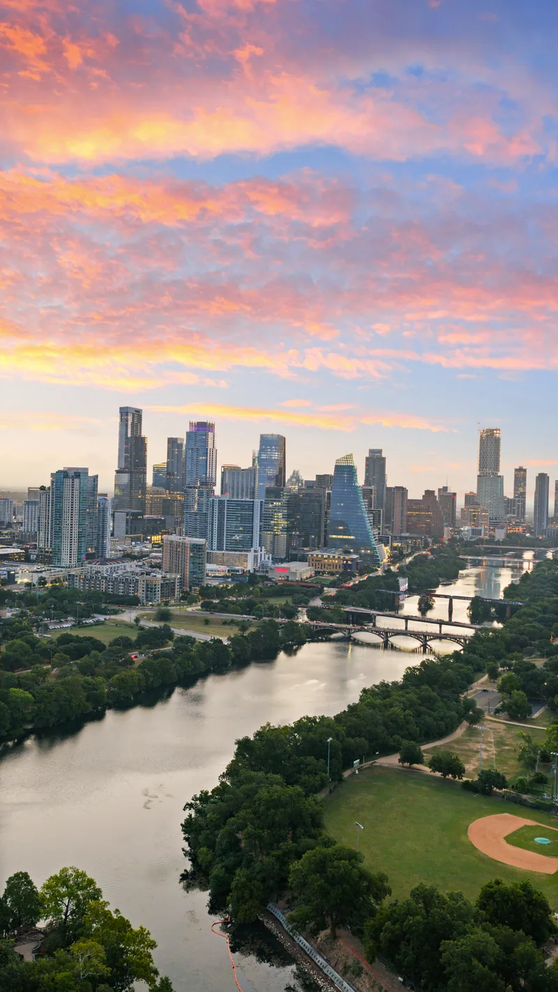 Vertical aerial view of the river and Austin skyline at sunrise