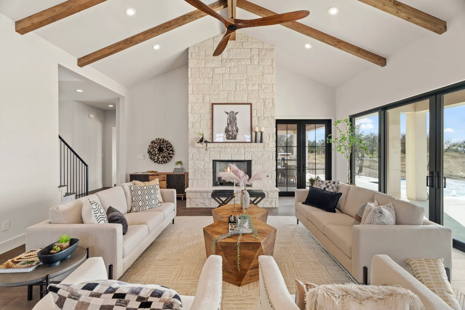 Bright living room with wood ceiling beams, fireplace and glass doors