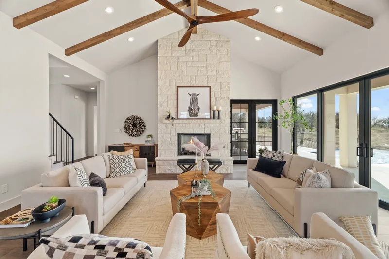 Bright living room with wood ceiling beams, fireplace and glass doors
