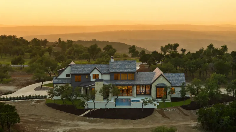 Home and pool overlooking rolling hills at sunset