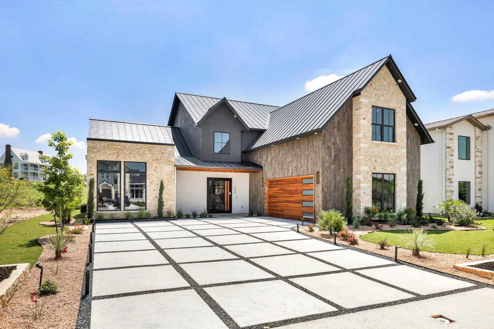 Stone home exterior with a landscaped entry and driveway