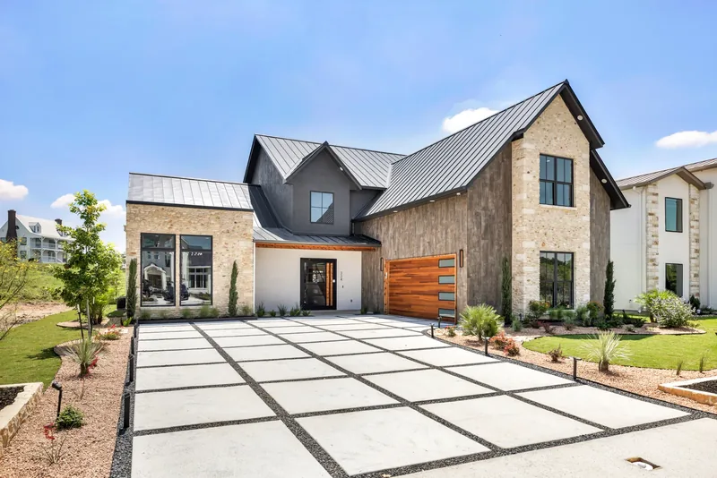 Stone home exterior with a landscaped entry and driveway
