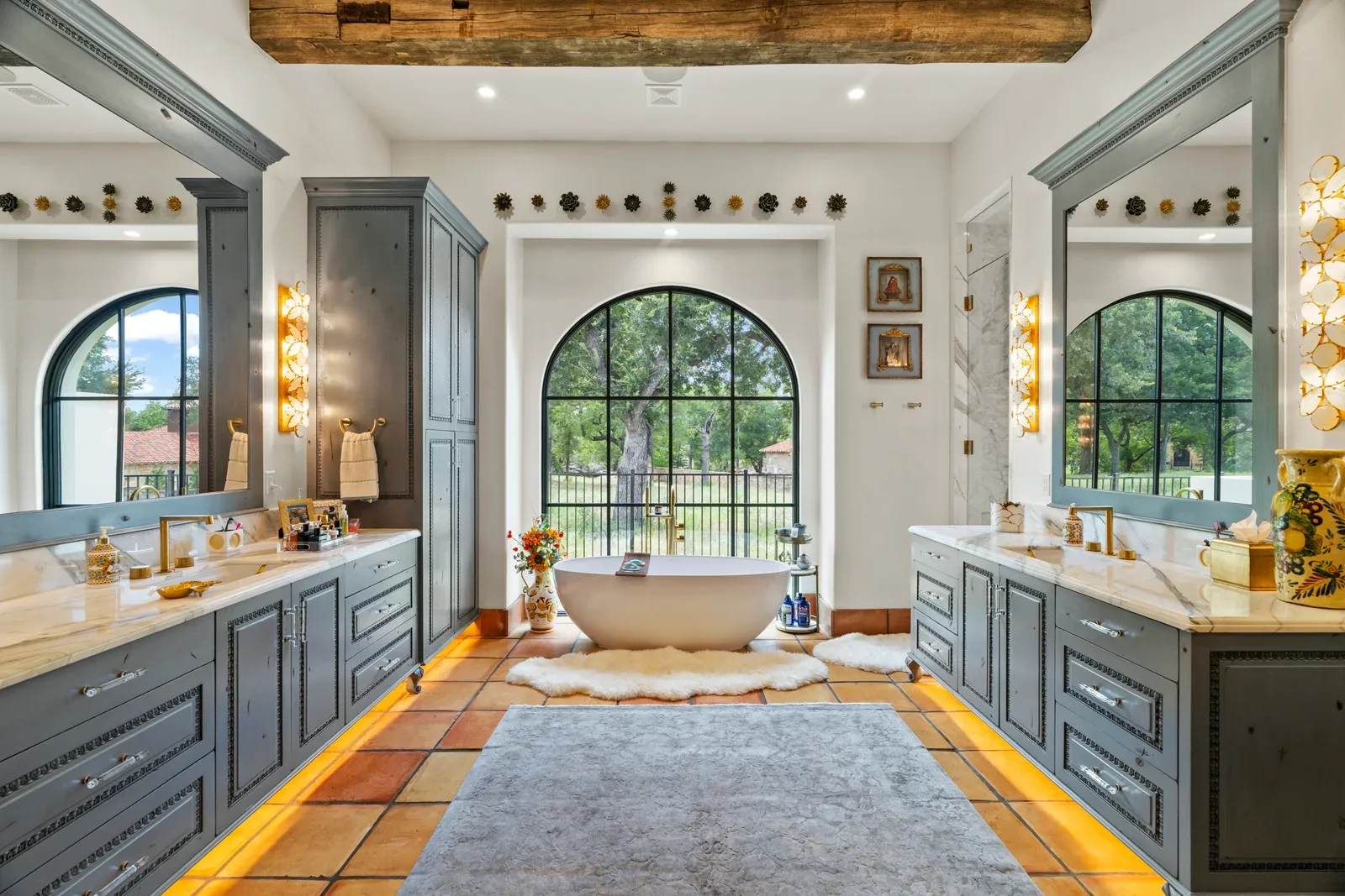 Bathroom with freestanding tub, arched windows and built-in cabinetry