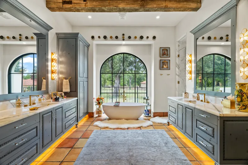 Bathroom with freestanding tub, arched windows and built-in cabinetry