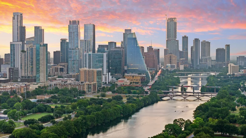 Austin skyline and river from the air beneath a pink sky