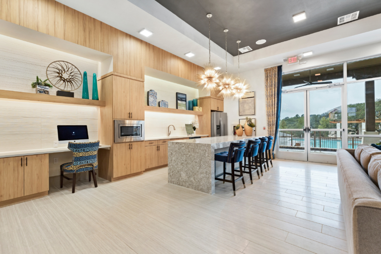 Apartment clubhouse with seating, work areas and a pool view