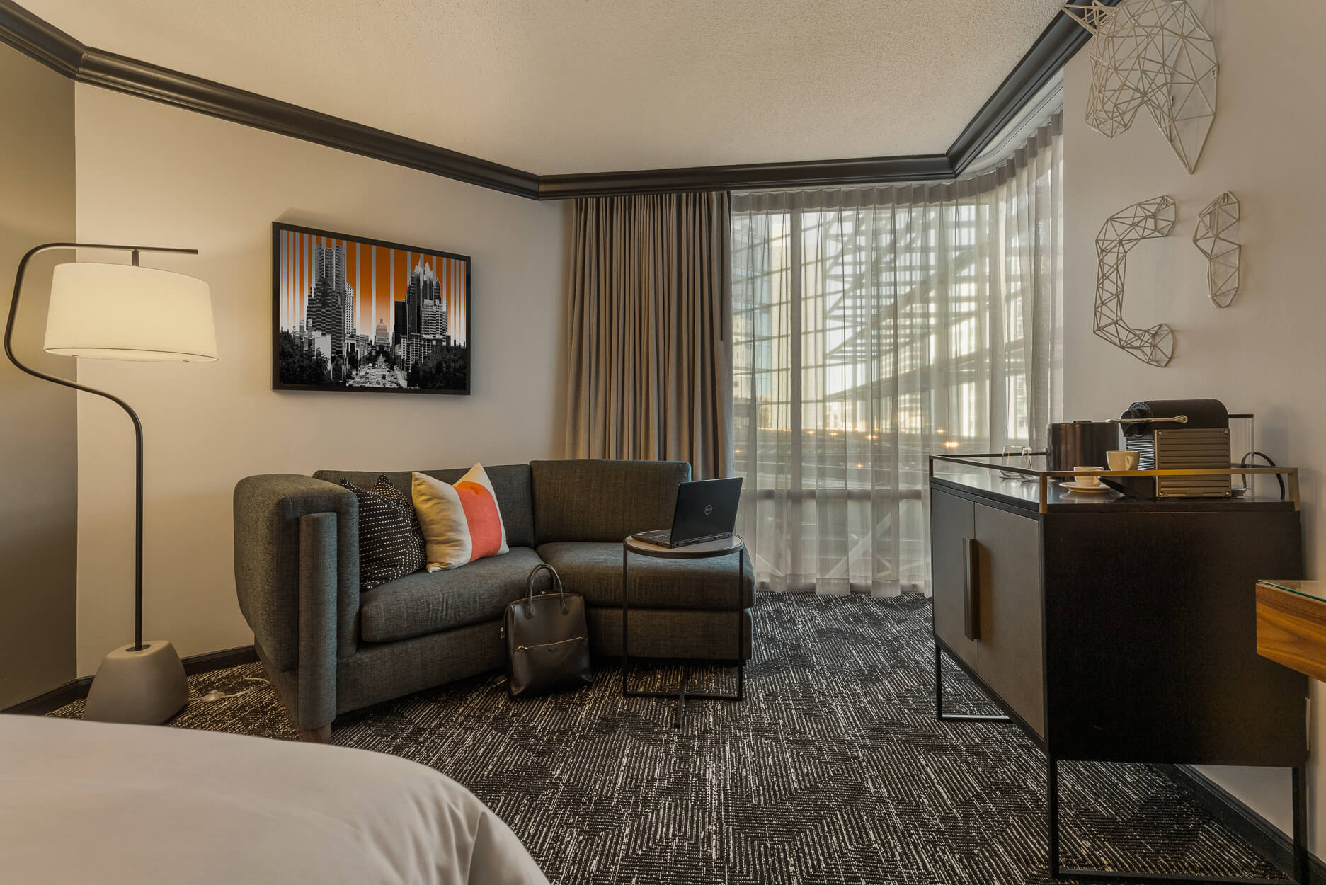 Hotel guest room with a sofa, desk and window