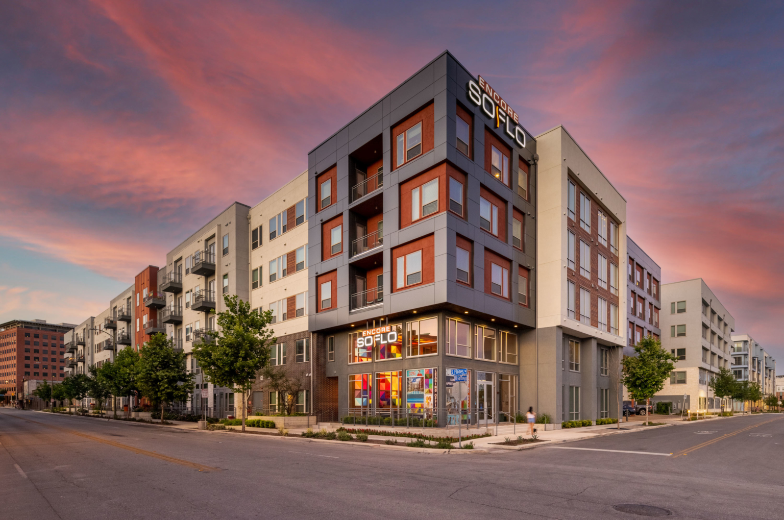 Street-level view of a San Antonio apartment community at twilight.