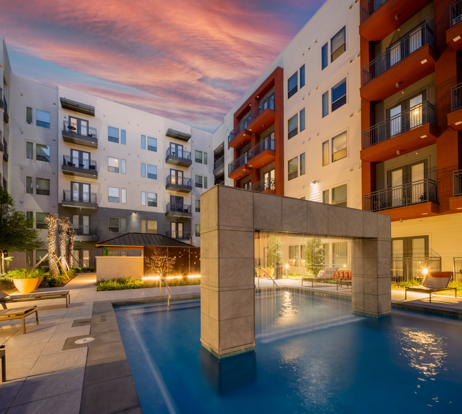 Shared pool and courtyard at a San Antonio apartment community at twilight.